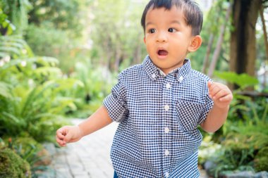 Küçük Asyalı çocuk bahçede oynuyor. Kahve parkında. Doğada mutlu zaman çocuğu.