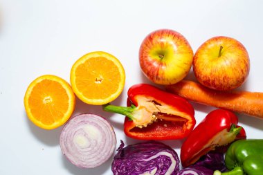 Beyaz arka planda çeşitli renkli sebze dilimleri sağlıklı yiyecekler.