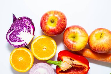 Beyaz arka planda çeşitli renkli sebze dilimleri sağlıklı yiyecekler.