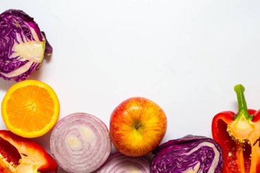 Beyaz arka planda çeşitli renkli sebze dilimleri sağlıklı yiyecekler.