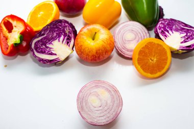 Beyaz arka planda çeşitli renkli sebze dilimleri sağlıklı yiyecekler.