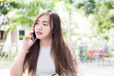 İş kadını Asyalı kadınlar kahve dükkanında cep telefonu kullanıyor, akıllı telefonlu güzel kadınlar.