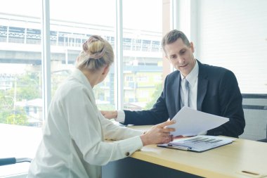 Profesyonel işadamı, modern ofiste sekreterle konuşuyor. Açıkla bakalım.