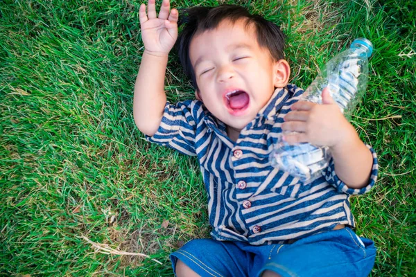 Toddler Baby Boy Lying Green Grass Field Holding Water Bottle — Stock Photo, Image