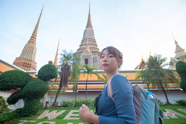 Güzel Asyalı sırt çantalı kadın Bangkok Tayland 'da pagoda ile birlikte gizli bir Budist tapınağında seyahat ediyor.