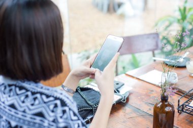 Kafede akıllı telefon kullanan Asyalı kadın