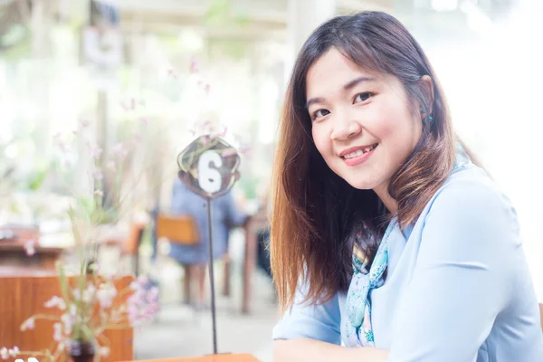 美丽的亚洲女人坐在咖啡店里 微笑着看着相机 — 图库照片