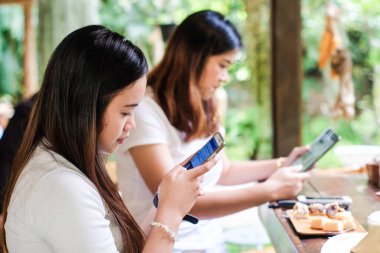 Kafede akıllı telefondan mesajlaşan kadınlar ellerinizi yakın tutun.