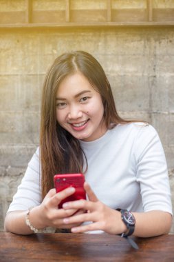 Ahşap sehpanın üzerinde, akıllı telefon mesajları kullanan insanların eliyle Latte art kahve.