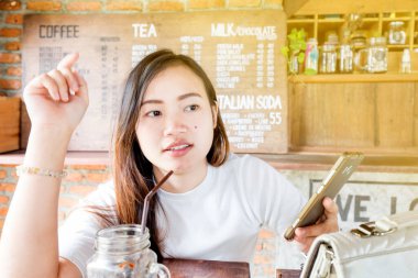 Ahşap sehpanın üzerinde, akıllı telefon mesajları kullanan insanların eliyle Latte art kahve.