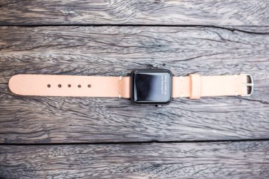 Akıllı saat deri kayışı ahşap masada.