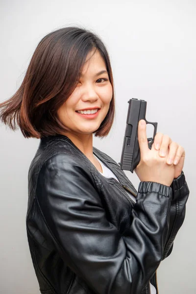 漂亮的亚洲女侦探拿着枪在白人背景下摆姿势 — 图库照片