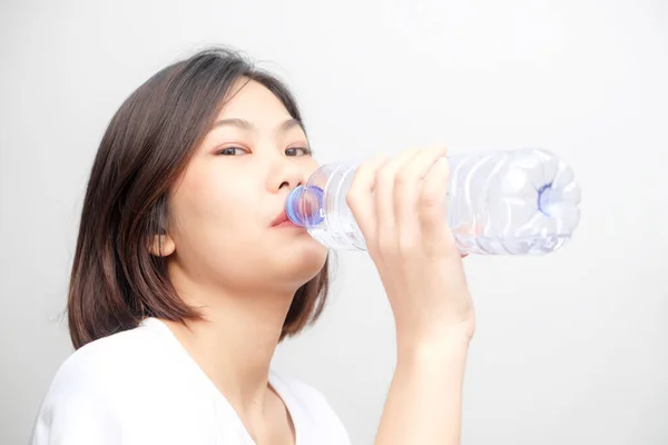 Young asian woman drinking water from bottle isolated on white background