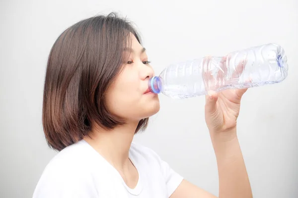 Young asian woman drinking water from bottle isolated on white background