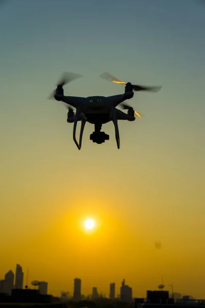 Silueta Quadcopter Volando Sobre Ciudad Atardecer —  Fotos de Stock