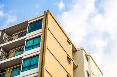Mavi gökyüzüne karşı birçok penceresi olan modern apartman binası, şehir konutu