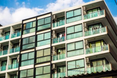 Mavi gökyüzüne karşı birçok penceresi olan modern apartman binası, şehir konutu