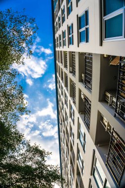 Mavi gökyüzüne karşı birçok penceresi olan modern apartman binası, şehir konutu