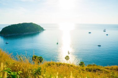 Phuket Adası 'nda gün batımı. Sarı otlu turkuaz deniz suyu, yaz tatili konsepti.