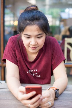 Kafede akıllı telefon kullanan Asyalı kadın