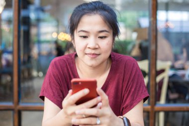 Kafede akıllı telefon kullanan Asyalı kadın