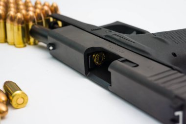 Beyaz arka planda mermisi olan 9mm otomatik sompact tabanca.