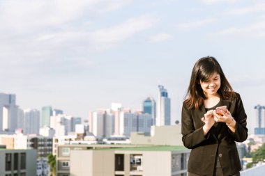 Yürütücü çatı üst işyeri binalarının arka planda bir cep telefonu ile çalışma