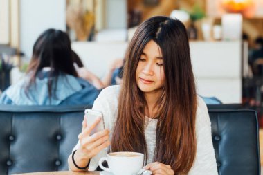 Kafede oturan ve smartphone kahve ile konuşurken Üniversitesi Asya iş öğrenci