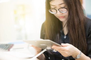 Kadın genç ofis iş Kütüphanesi öğrenme için dijital tablet kullanma