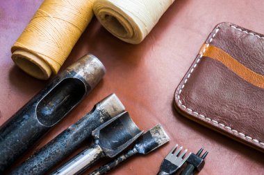 Deri el sanatları için cüzdan deri craftman'ın çalışma masası üzerinde aracı ile çalışma .