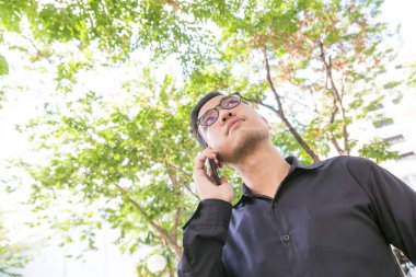 Yeşil park, iletişim iş kavramı cep telefonu konuşurken iş adamı