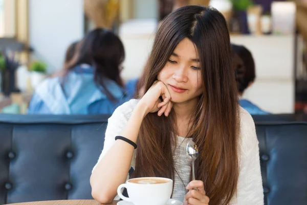 Cafe latte Kütüphanesi'nde serbest zaman sırasında kafede kahve ile mutlu Asyalı kadın