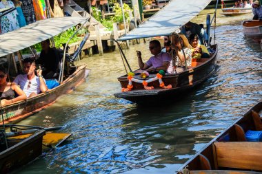 25 Mart 2017 'de Bangkok' ta Damnoen Saduak yüzer pazarında turistlerle tekne servisi. Geleneksel alışveriş ve satış yeri Tayland 'ın Damnoen Saduak kanallarında hala uygulanmaktadır.