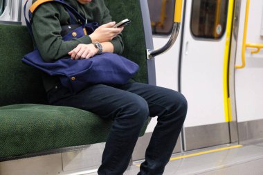 İş adamı Japonya 'da akıllı telefon kullanıyor. JR şehrinde trende oturuyor. Yaklaş.
