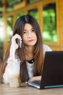 Kafede otururken akıllı telefondan konuşan Asyalı güzel kadınlar, cep telefonlu iş kadınları.