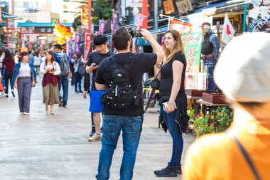 ASAKUSA, TOKYO, JAPAN - 20 Ekim 2016: Asakusa 'daki Nakamise alışveriş caddesinde güneşli bir günde eğlenen turistler Tokyo' nun en popüler yerlerinden Asakusa 'daki Sensoji Tapınağı' na bağlanıyorlar.