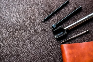 Hakiki deri cüzdan yapan bir alet. Sığır derisi üzerinde işçilik atölyesi.