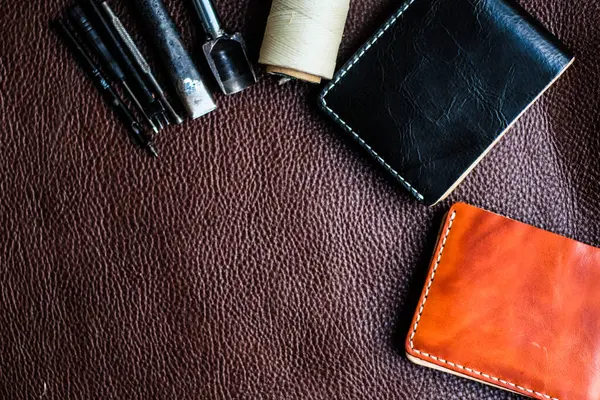 Tool making genuine leather wallet craftsmanship workshop flatlay on cowhide