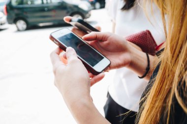 Bir grup iş kadını dışarıda akıllı telefon kullanıyor. Teknoloji bağımlılığı.