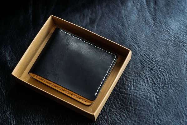 Vegetable tanned leather wallet on black leather background, Craftsmanship object