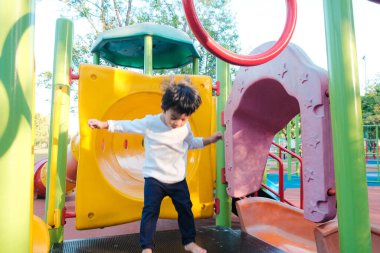 Mutlu çocuk şehir parkında oyun parkında eğleniyor. 