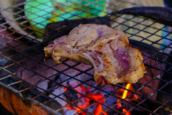 在燃烧的火焰上放上烤架上的猪肉牛排 — 图库照片