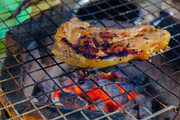 在燃烧的火焰上放上烤架上的猪肉牛排 — 图库照片