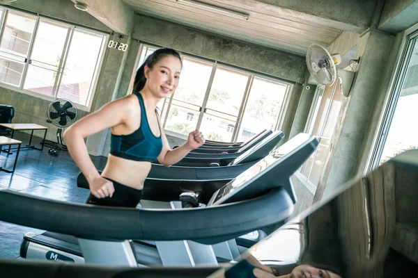 Beautiful sport asian woman jogging walk on running treadmill indoor sport gym