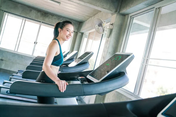 Beautiful sport asian woman jogging walk on running treadmill indoor sport gym