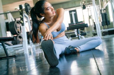 Spor salonunda spor yaparken Asyalı kadınlar kas gerer.