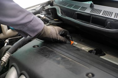 Tamirci el yordamıyla motor yağını kontrol ediyor. Araç bakım onarımı. Motor taşımacılığı endüstrisini kapatın.