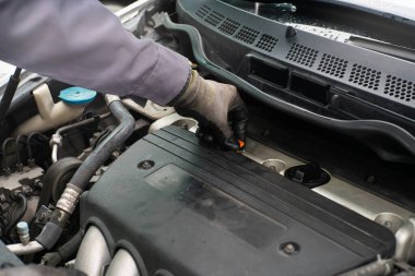 Tamirci el yordamıyla motor yağını kontrol ediyor. Araç bakım onarımı. Motor taşımacılığı endüstrisini kapatın.
