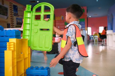 Anaokulu Asyalı çocuk oyun makinisti mekanik bina işçisi renk bloğu bina kapalı oyun alanı