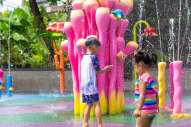 Mutlu çocuk ve kız suyun tadını çıkarıyorlar. Su parkında yaz tatili.